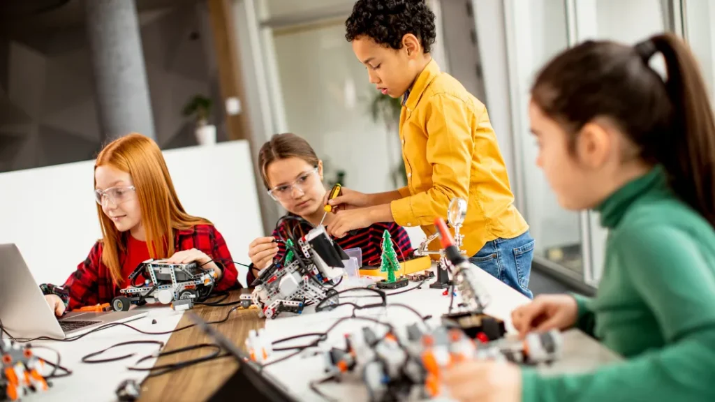 Niños trabajando en robots de Lego en un aula.